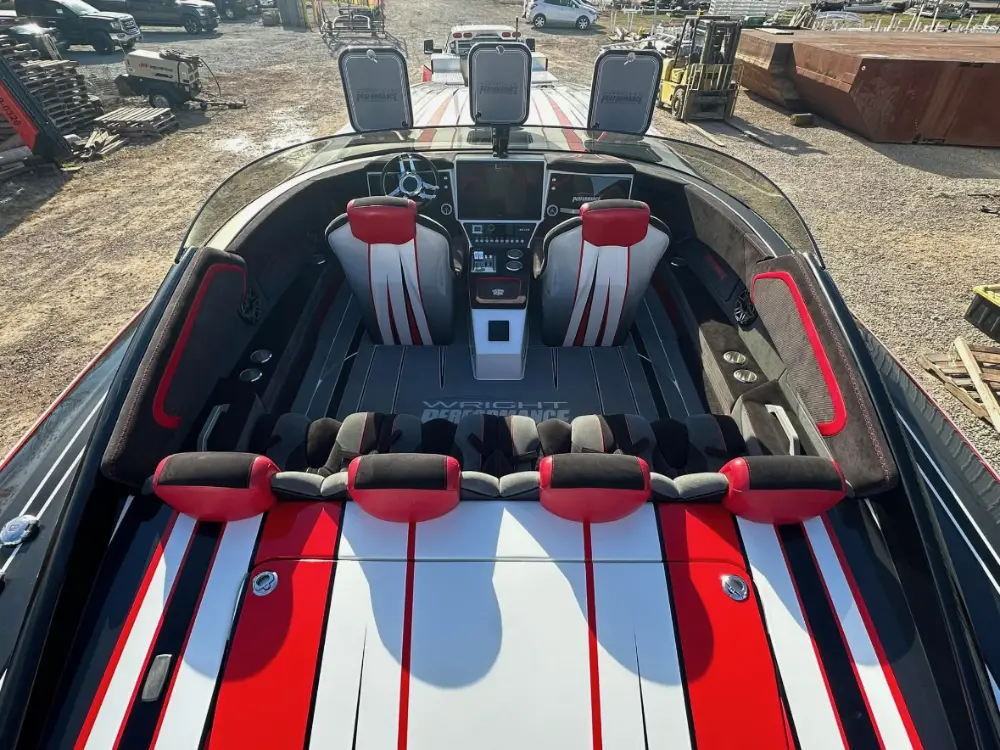 Interior cockpit view of a high-performance powerboat featuring red, white, and black custom seating.
